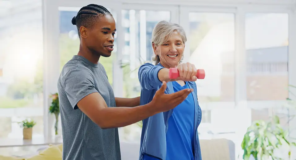 Young physical therapists working with a patient lifting a small weight